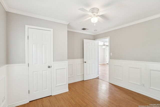 unfurnished bedroom with crown molding, ceiling fan, and light hardwood / wood-style flooring