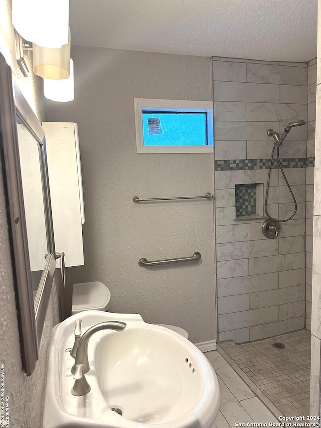 1505 B St, Floresville, TX 78114 - full bathroom with marble finish floors, a sink, and a tile shower