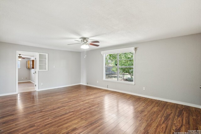 spare room with ceiling fan, dark hardwood / wood-style flooring, and a textured ceiling