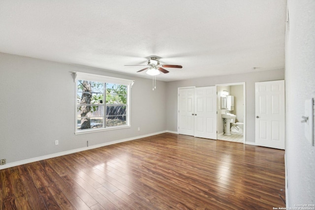 1505 B St, Floresville, TX 78114 - unfurnished bedroom with wood finished floors, ensuite bath, baseboards, a ceiling fan, and a textured ceiling