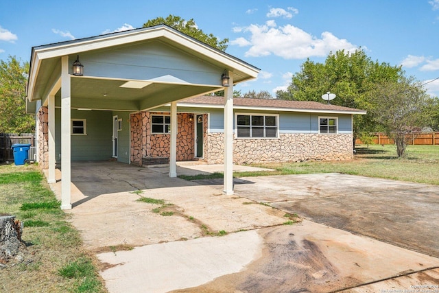 1505 B St, Floresville, TX 78114 - view of front of property with stone siding, concrete driveway, and a carport