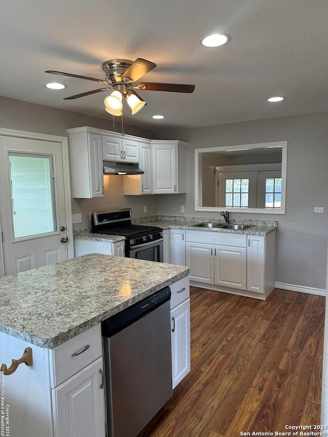 kitchen featuring sink, dark wood-type flooring, appliances with stainless steel finishes, white cabinetry, and a textured ceiling