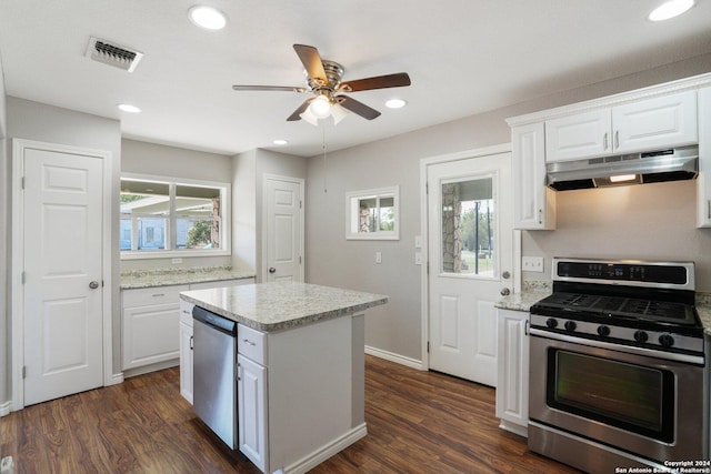 1505 B St, Floresville, TX 78114 - kitchen with under cabinet range hood, stainless steel appliances, ceiling fan, dark wood-style floors, and white cabinetry