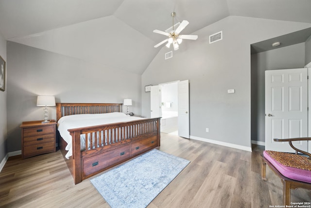 bedroom with high vaulted ceiling, light wood-type flooring, ceiling fan, and ensuite bathroom