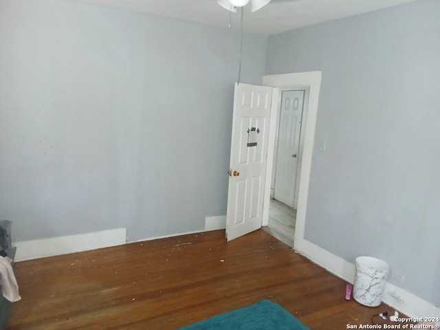 unfurnished room with ceiling fan and dark wood-type flooring