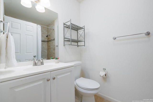 bathroom featuring toilet, vanity, and tiled shower