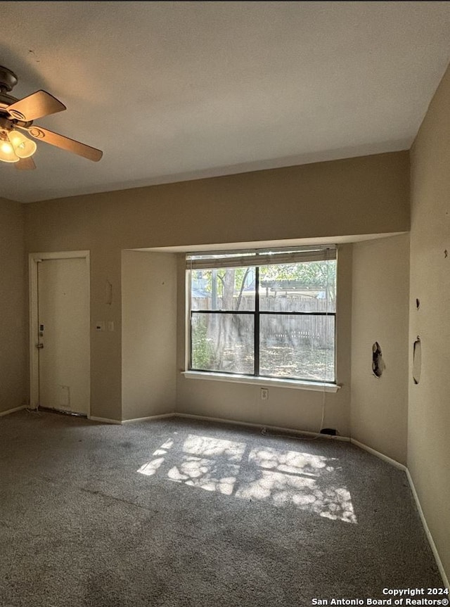 carpeted spare room featuring ceiling fan