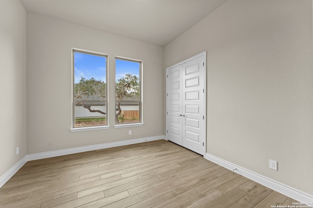 unfurnished bedroom with light hardwood / wood-style flooring and a closet