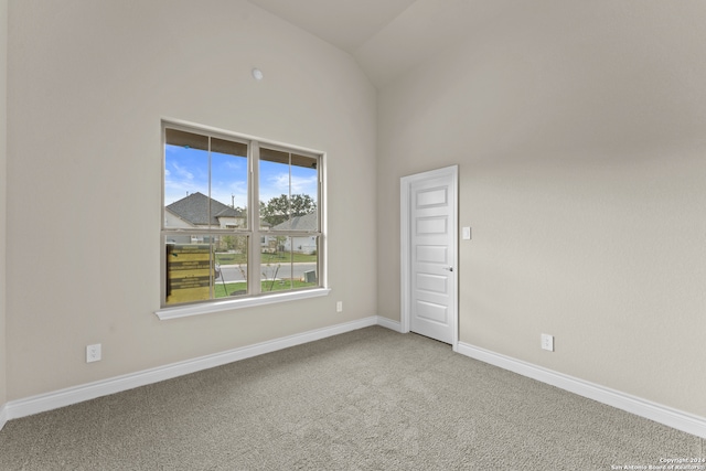 empty room featuring carpet flooring and lofted ceiling