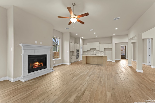 unfurnished living room with light wood-type flooring and ceiling fan