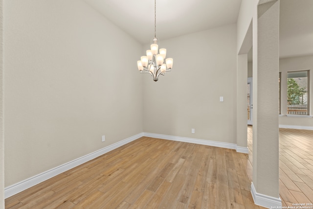 unfurnished room featuring light hardwood / wood-style floors and a notable chandelier