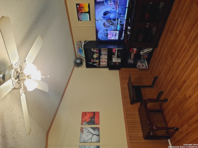 interior space with wooden walls and ceiling fan