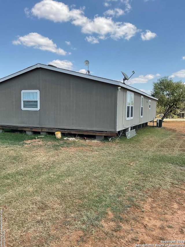 view of side of home with a yard