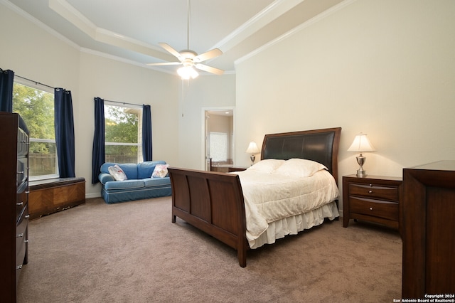 carpeted bedroom featuring ceiling fan, a raised ceiling, and ornamental molding