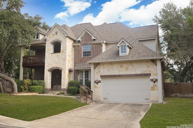 view of front of house with a balcony and a front lawn