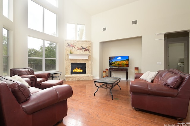 living room with hardwood / wood-style floors, high vaulted ceiling, and a healthy amount of sunlight