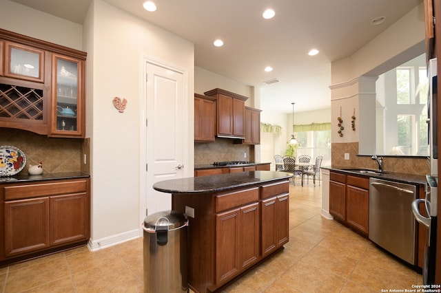 kitchen with pendant lighting, a kitchen island, decorative backsplash, and stainless steel dishwasher