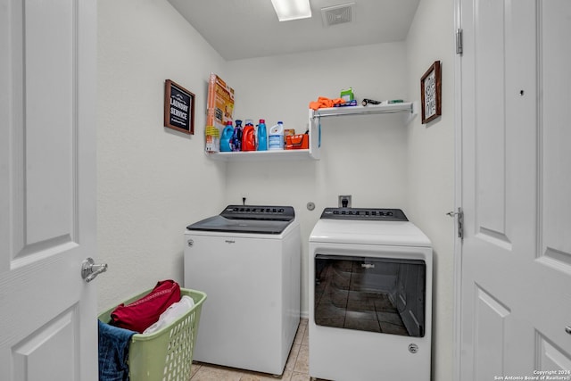 laundry area with light tile patterned floors and washing machine and dryer