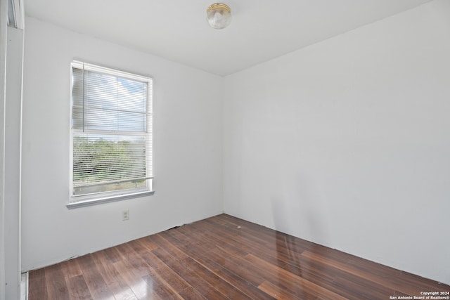 unfurnished room with dark hardwood / wood-style flooring and a healthy amount of sunlight