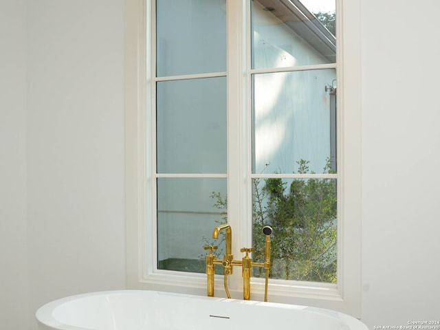 bathroom featuring sink and a tub to relax in