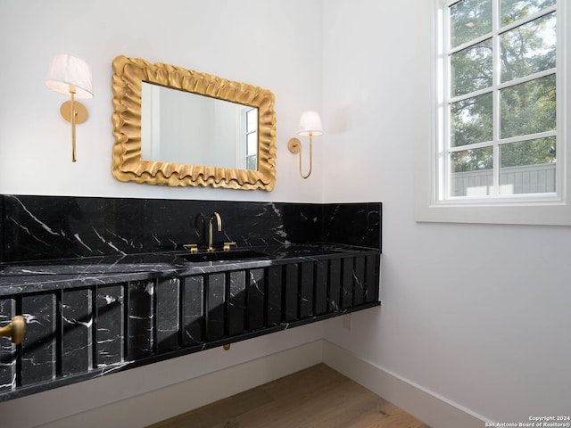 bathroom with hardwood / wood-style floors, sink, and tasteful backsplash