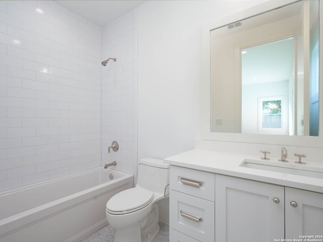 full bathroom with vanity, tiled shower / bath, and toilet