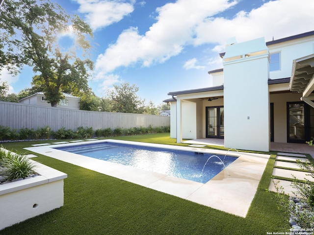 view of pool featuring a patio, pool water feature, a yard, and ceiling fan