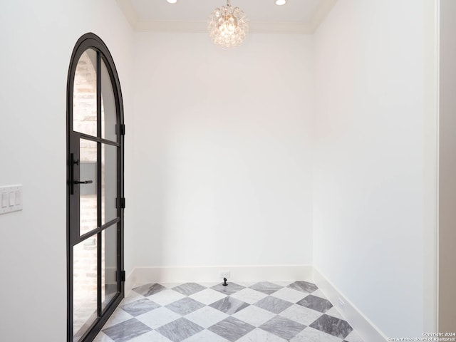 empty room with ornamental molding and a chandelier