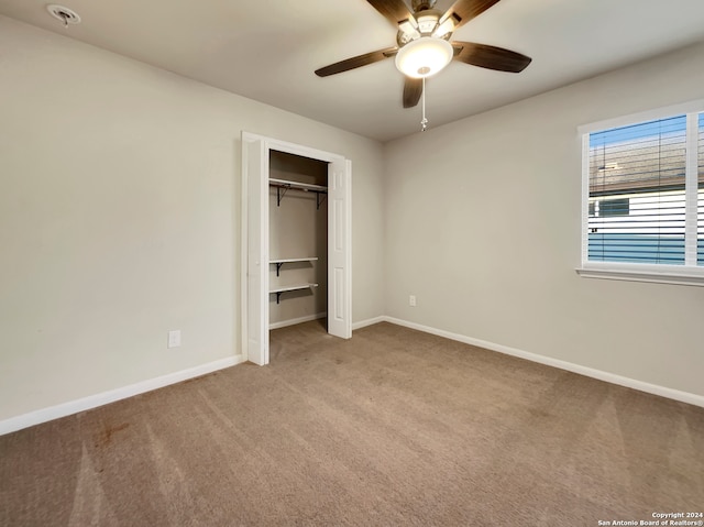 unfurnished bedroom featuring a closet, light carpet, and ceiling fan