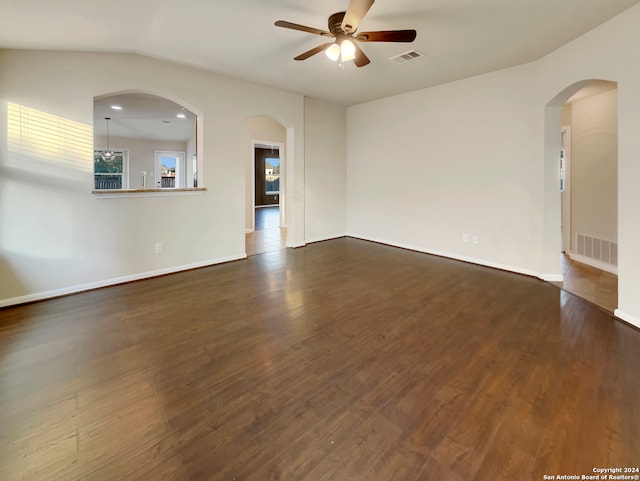 spare room with ceiling fan, dark wood-type flooring, and vaulted ceiling