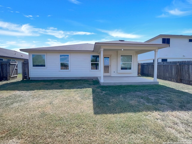 rear view of house with a patio and a lawn