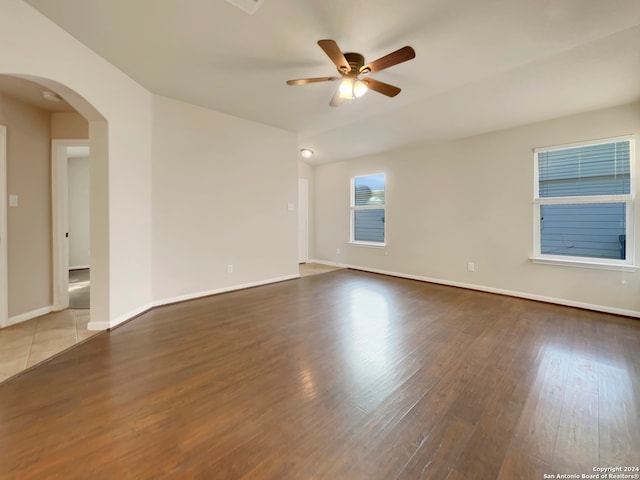 empty room with ceiling fan and dark hardwood / wood-style flooring