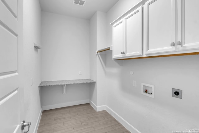 washroom featuring hookup for a washing machine, cabinets, light hardwood / wood-style flooring, and hookup for an electric dryer