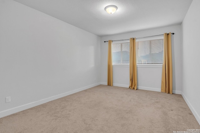 carpeted spare room with a textured ceiling