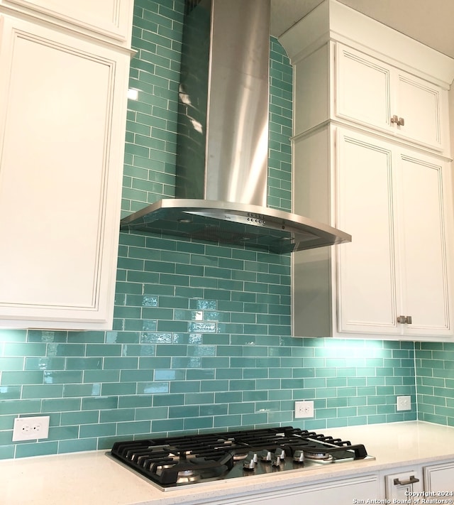 kitchen featuring wall chimney exhaust hood, stainless steel gas stovetop, and tasteful backsplash