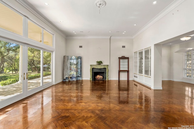 unfurnished living room with parquet floors, a towering ceiling, and ornamental molding