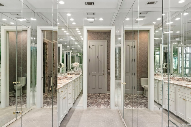 bathroom featuring toilet, a shower with shower door, and vanity