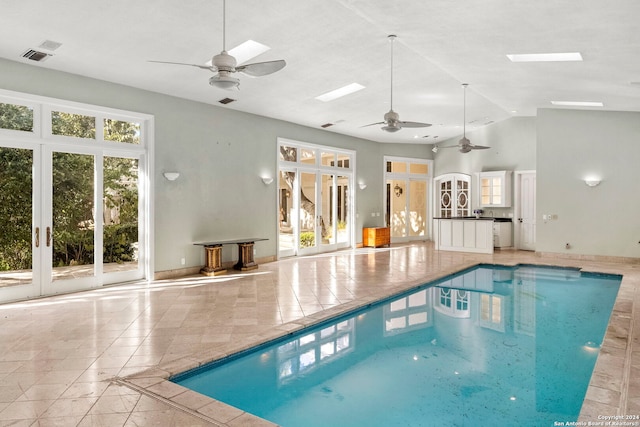 view of pool with a skylight and ceiling fan