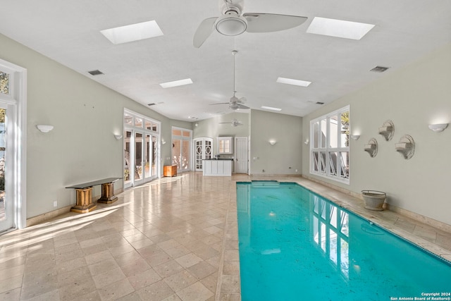 view of swimming pool with a skylight and ceiling fan