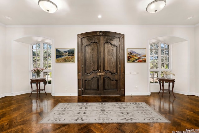 entryway with crown molding and dark parquet flooring