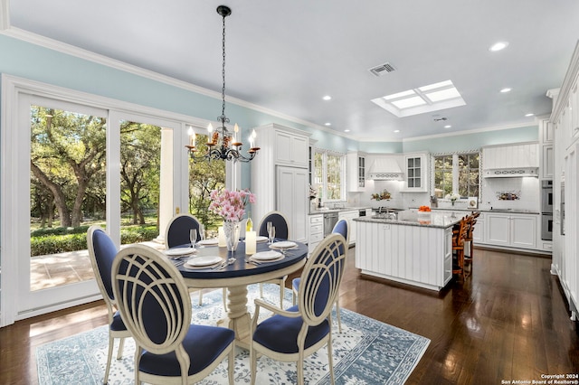 dining area featuring an inviting chandelier, crown molding, a skylight, and dark hardwood / wood-style flooring