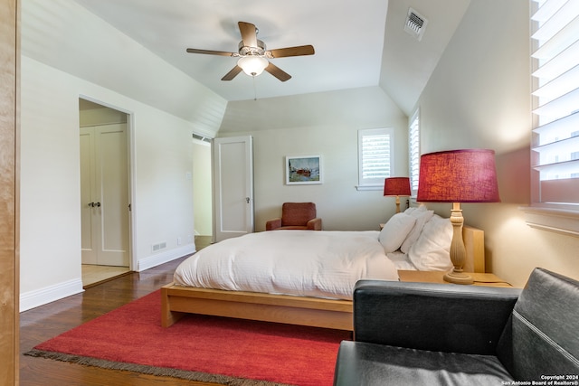 bedroom featuring lofted ceiling, multiple windows, ceiling fan, and dark hardwood / wood-style flooring