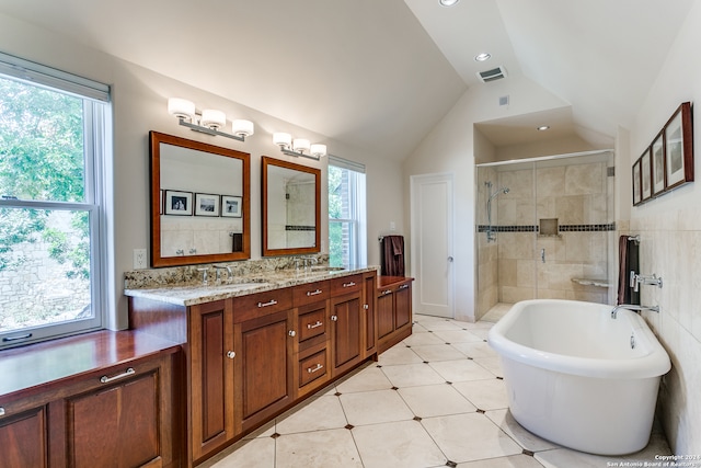 bathroom featuring shower with separate bathtub, vanity, lofted ceiling, and plenty of natural light