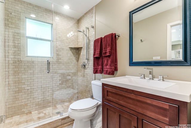 bathroom with an enclosed shower, vanity, and toilet