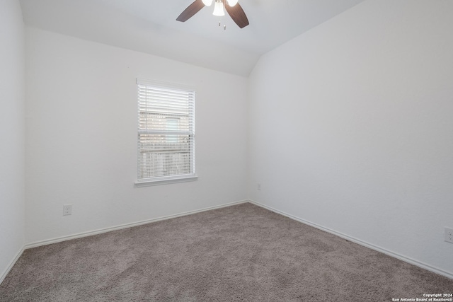 carpeted spare room featuring ceiling fan and vaulted ceiling