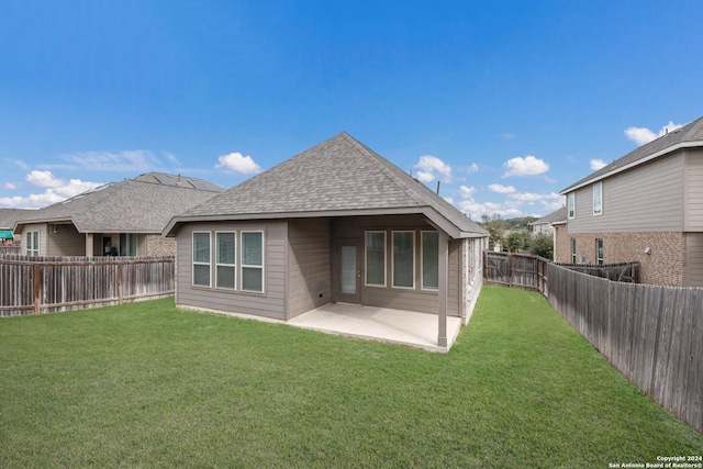 rear view of property with a lawn and a patio