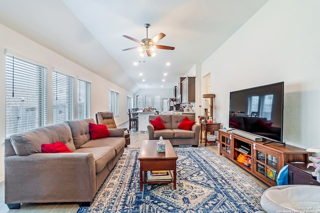 living room with wood-type flooring, ceiling fan, and lofted ceiling