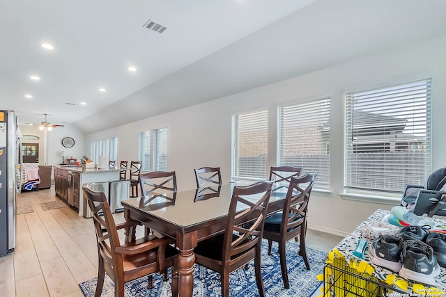 dining area featuring ceiling fan, light wood-type flooring, and lofted ceiling