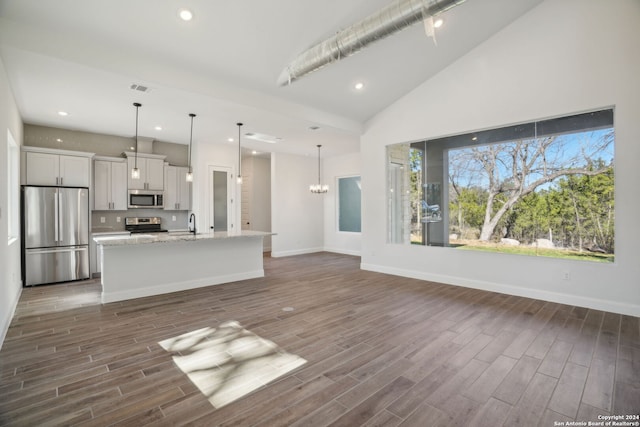 unfurnished living room with a notable chandelier, dark hardwood / wood-style flooring, and sink