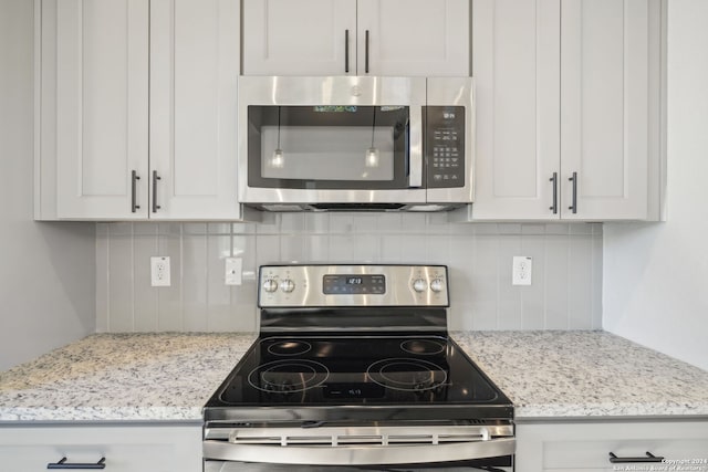 kitchen with white cabinets, light stone countertops, and appliances with stainless steel finishes